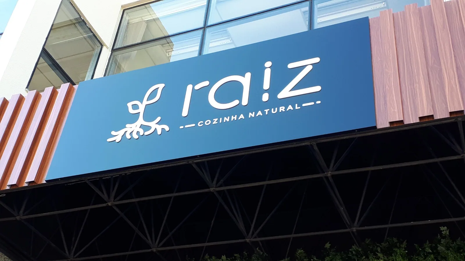 Raiz — Fachada comercial com identidade em grande formato